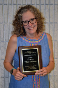 Tiffany Sandstrum holding the award for Academic Advisor of the Year